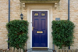 Photo of a blue door flanked by trees via istockphoto.com.